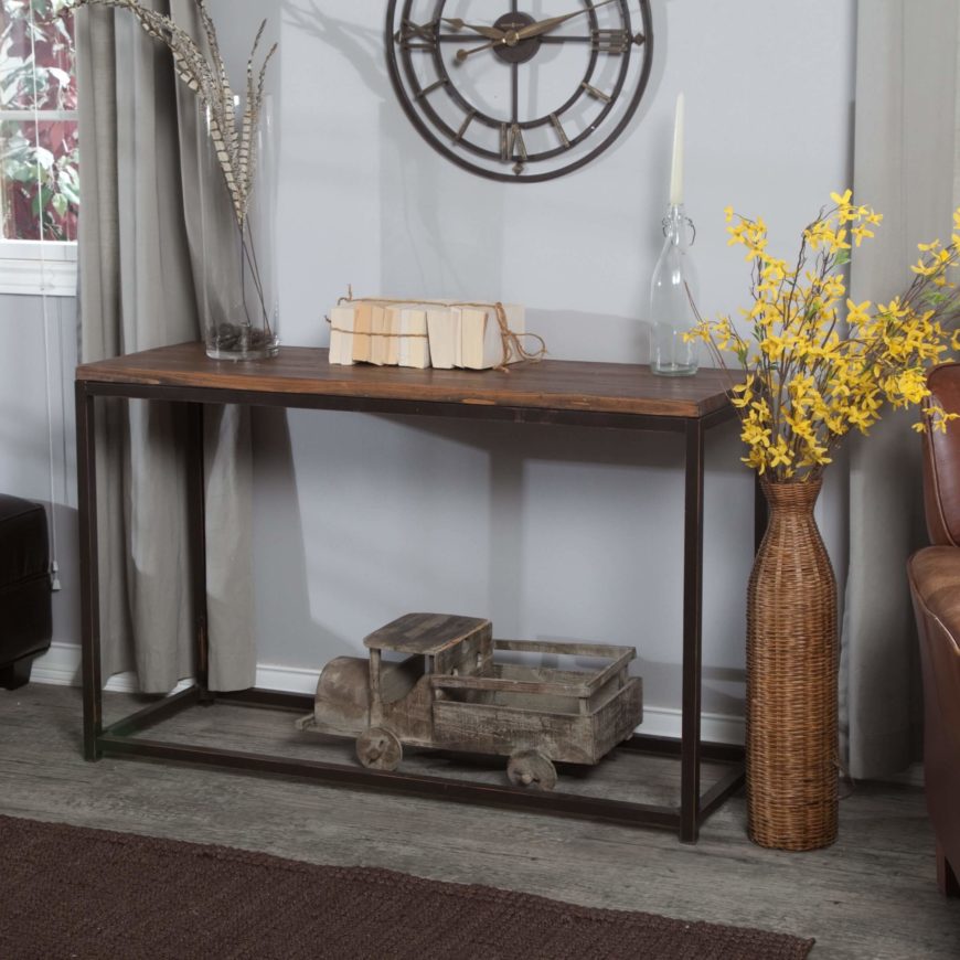 A distressed metal frame is topped with reclaimed wood, creating a rustic table with an industrial cast to it. The bottom of the table is entirely open, and perfect for storing a large accent item, like the truck in the image below. A distressed metal frame is topped with reclaimed wood, creating a rustic table with an industrial cast to it. The bottom of the table is entirely open, and perfect for storing a large accent item, like the truck in the image below.