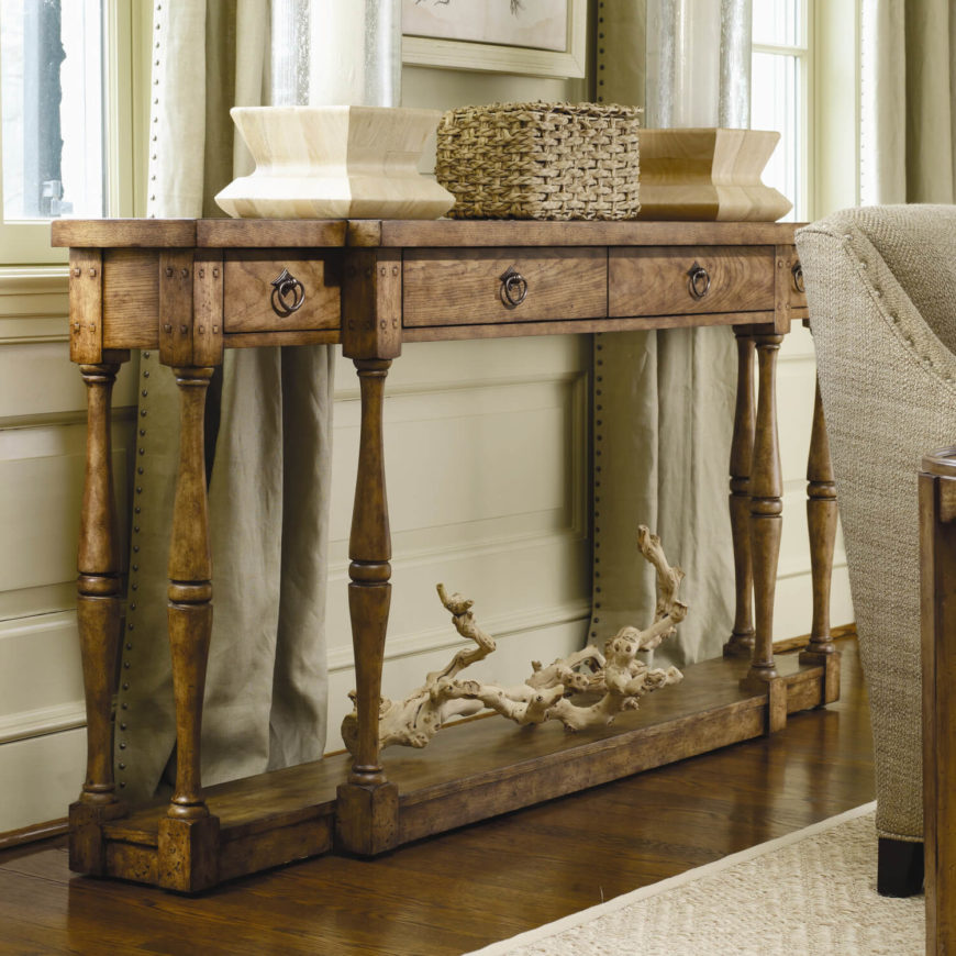 Rivets and other structural elements are visible on this wooden table, which gives it a more dated, rustic feel, while still remaining an elegant carved piece of furniture. Rivets and other structural elements are visible on this wooden table, which gives it a more dated, rustic feel, while still remaining an elegant carved piece of furniture.