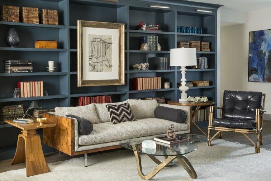 For owners with a smaller collection, arranging like items together with knick-knacks and accent pieces is a great way to fill the vertical space. This design also attaches a large piece of artwork to the empty shelves just above the sofa. For owners with a smaller collection, arranging like items together with knick-knacks and accent pieces is a great way to fill the vertical space. This design also attaches a large piece of artwork to the empty shelves just above the sofa.