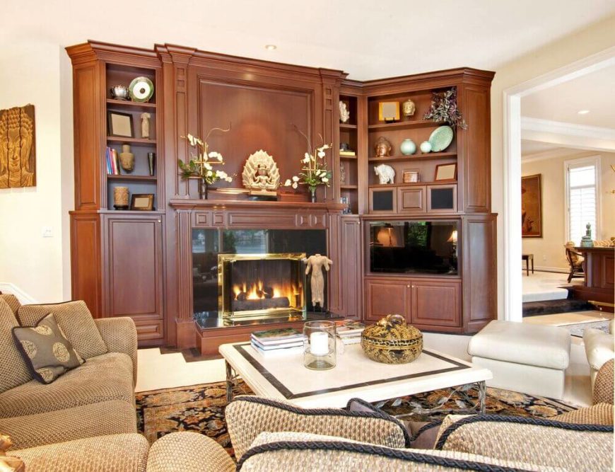 Exotic sculptures and artwork are displayed on the mantle and shelves surrounding this fireplace and entertainment center. Exotic sculptures and artwork are displayed on the mantle and shelves surrounding this fireplace and entertainment center.
