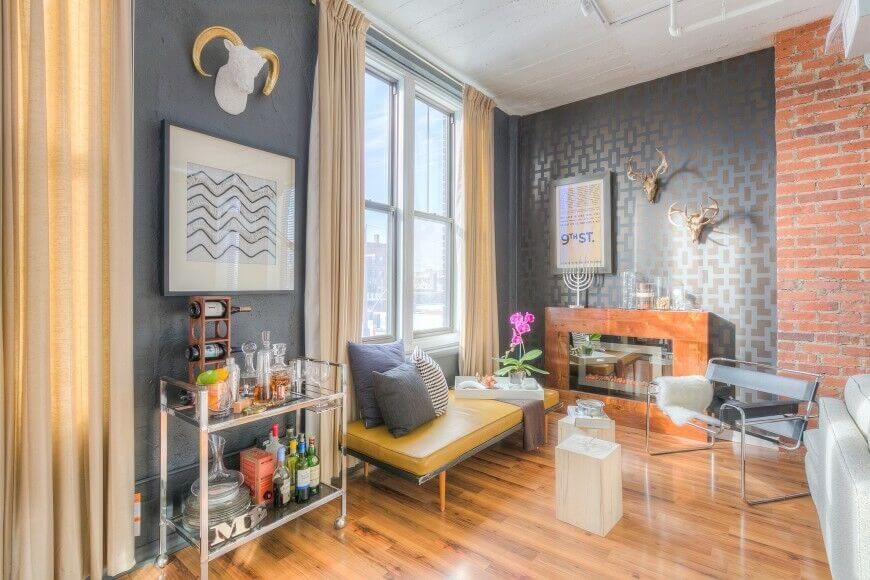 Brick is next to a rich gray wall with a subtle painted stencil. Small, low profile pieces of furniture are layered with patterned pillows. Brick is next to a rich gray wall with a subtle painted stencil. Small, low profile pieces of furniture are layered with patterned pillows.