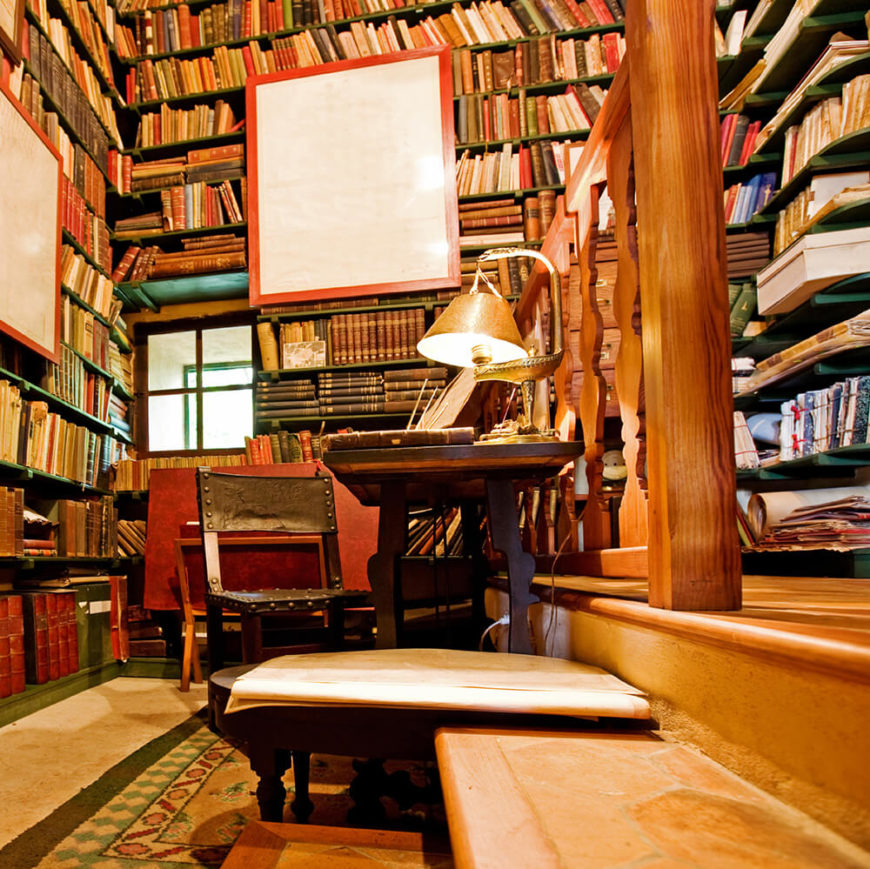 A close up look at this home library's study desk. The multiple bookshelves look so amazing.
