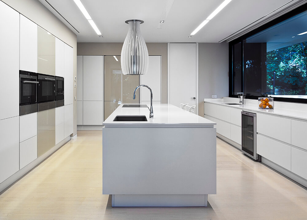 Modish kitchen with smooth white counters and countertops. The large center island looks elegant.