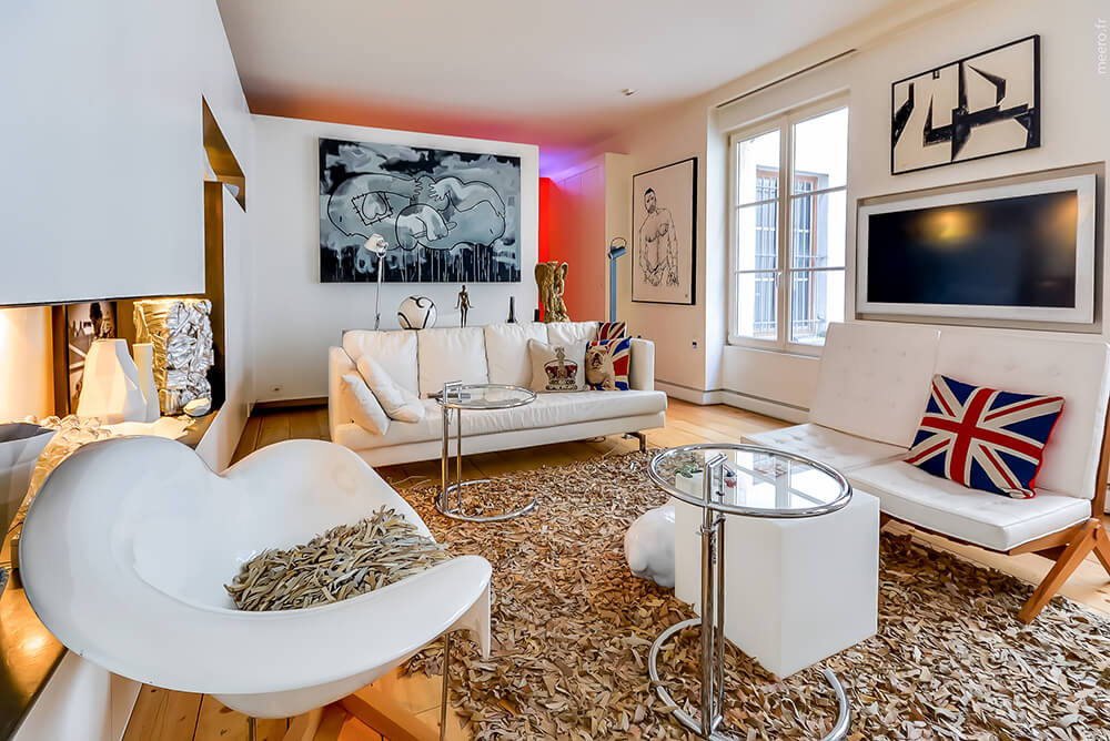 Modern living room with white seats matching the white walls. The rug looks so stylish.