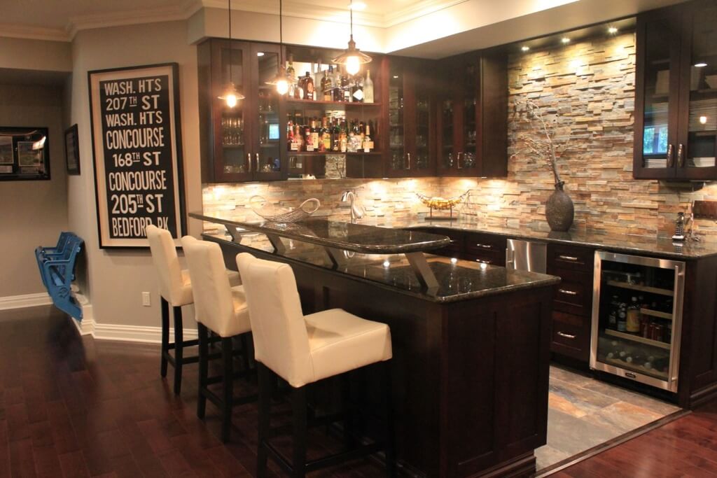 This home features a bar area with a stylish counter paired by white bar stools. The warm white lights look perfect together with the bar's style.
