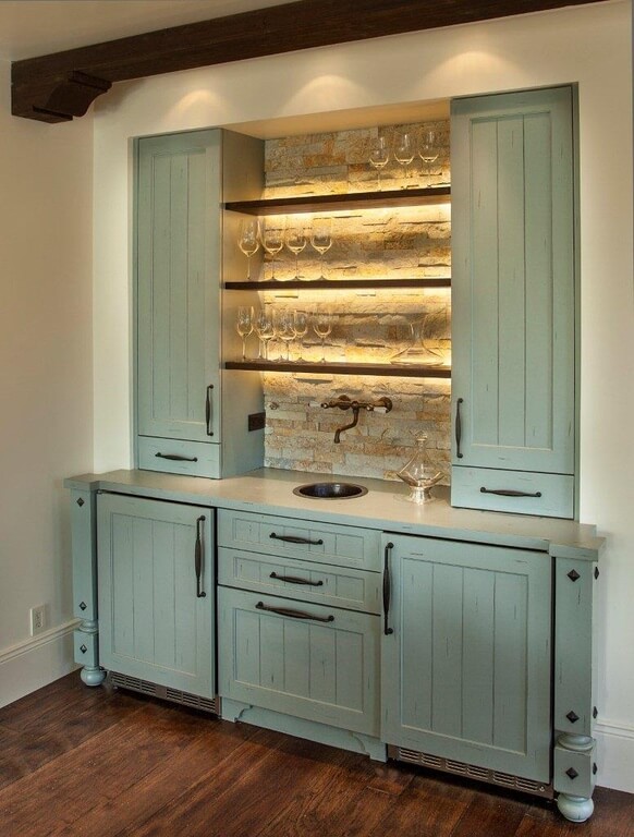 A close up look at the home's bar counter with green finish and set on the hardwood flooring.