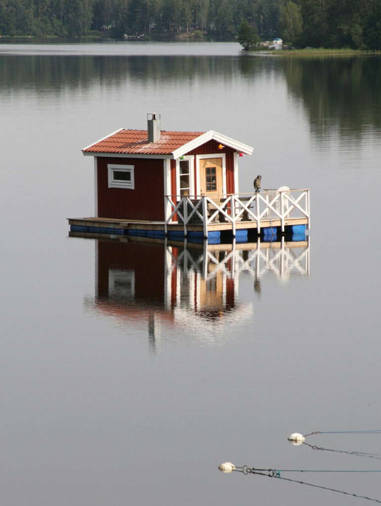 Another shanty boat with a small shed-sized home on the deck and a fenced off area on the front with a small opening for mooring for a smaller boat. Another shanty boat with a small shed-sized home on the deck and a fenced off area on the front with a small opening for mooring for a smaller boat.