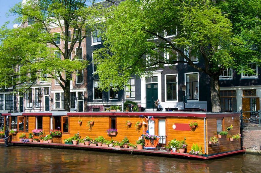 An enormously long houseboat with wooden siding and tons of garden containers throughout. This lovely permanent home is one of 2,400 in Amsterdam. An enormously long houseboat with wooden siding and tons of garden containers throughout. This lovely permanent home is one of 2,400 in Amsterdam.