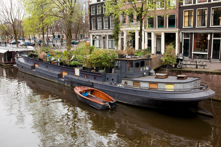 Another large ship-like houseboat located in Amsterdam. the top of the boat is filled with various potted trees. Another large ship-like houseboat located in Amsterdam. the top of the boat is filled with various potted trees.