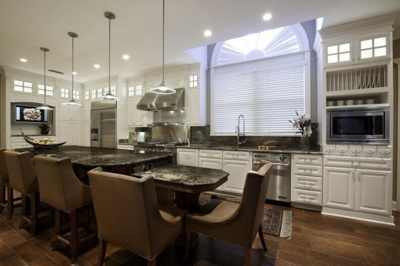 Stately leather chairs add class and color to this bright white kitchen while dark granite counters break up the use of white cabinets. Stainless steel appliances also help to break up the white and bring a bit of a modern look to this contemporary style. Stately leather chairs add class and color to this bright white kitchen while dark granite counters break up the use of white cabinets. Stainless steel appliances also help to break up the white and bring a bit of a modern look to this contemporary style.