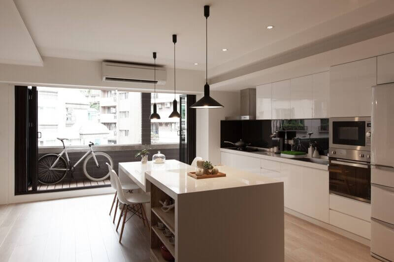 Simple white chairs fit the sleek modern design of this kitchen. High-gloss white cabinets and countertops allow for the solid black accents and sparse uses of natural wood to stand out even more from the rest of the room. Stainless steel accents throughout the room bring sophistication to this design. Simple white chairs fit the sleek modern design of this kitchen. High-gloss white cabinets and countertops allow for the solid black accents and sparse uses of natural wood to stand out even more from the rest of the room. Stainless steel accents throughout the room bring sophistication to this design.