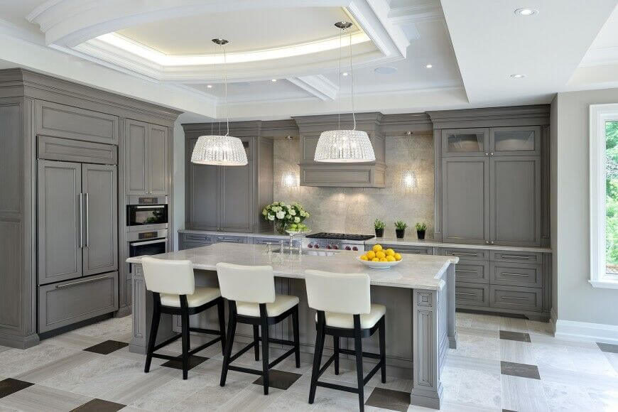 Dusky gray sets a classic tone for this kitchen. Highlighting it in bright white, silver, and black makes for a great contrast of colors the pale granite of the counters is carried up into the backsplash to brighten up the gray cabinets. Crystal light fixtures adds both sophistication and helps to diffuse the light around the room. Dusky gray sets a classic tone for this kitchen. Highlighting it in bright white, silver, and black makes for a great contrast of colors the pale granite of the counters is carried up into the backsplash to brighten up the gray cabinets. Crystal light fixtures adds both sophistication and helps to diffuse the light around the room.