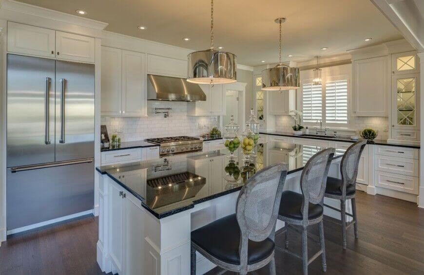 Splashes of dark colors break up this white kitchen, as do the chrome and stainless steel accents around the room. The high-gloss shine of the countertops helps to reflect more light up and around the room, despite the dark color of them. Splashes of dark colors break up this white kitchen, as do the chrome and stainless steel accents around the room. The high-gloss shine of the countertops helps to reflect more light up and around the room, despite the dark color of them.