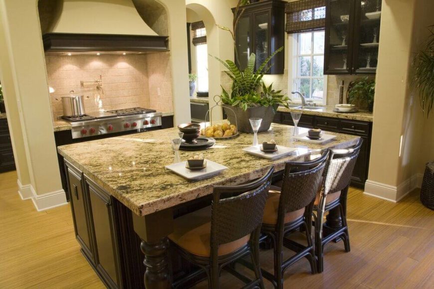 Chairs continue the color scheme of the room with dark wood and neutral tan seats. The island is large enough to offer plenty of space for cooking prep and double as a breakfast bar for three. Beige walls accent the dark cabinets and the granite counter top well. Chairs continue the color scheme of the room with dark wood and neutral tan seats. The island is large enough to offer plenty of space for cooking prep and double as a breakfast bar for three. Beige walls accent the dark cabinets and the granite counter top well.