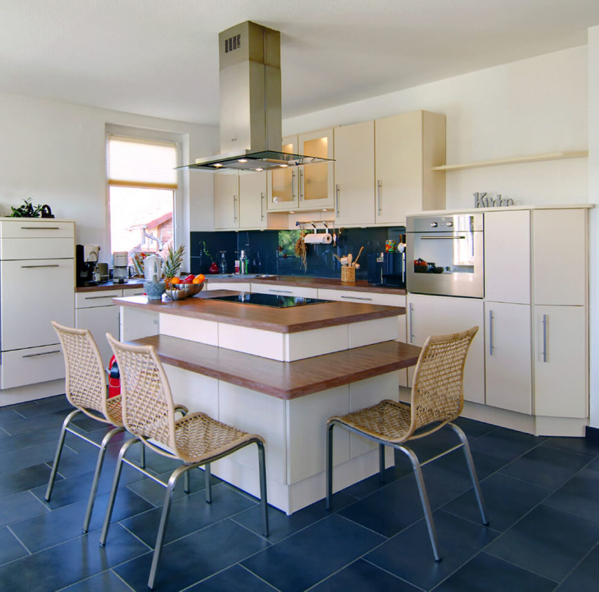 Bold blue tiles are enough to brighten up this space, so much so that the rest of the design can remain natural wood hues and white cabinetry. Separating the island cook space from the eating space of the counter is a genius idea and it allows the individual spaces to remain uncluttered. Bold blue tiles are enough to brighten up this space, so much so that the rest of the design can remain natural wood hues and white cabinetry. Separating the island cook space from the eating space of the counter is a genius idea and it allows the individual spaces to remain uncluttered.