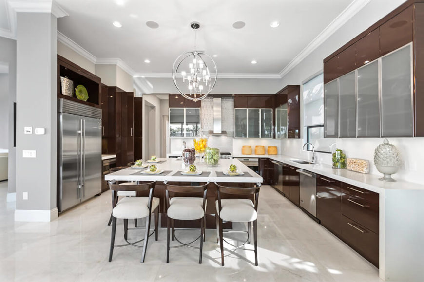 Chocolate brown and bright white strike an easy balance in this room with sleek silver hardware accents. The high-gloss sheen of the room makes sure to reflect plenty of light around the room and pops of bright colors liven up the kitchen design. Chocolate brown and bright white strike an easy balance in this room with sleek silver hardware accents. The high-gloss sheen of the room makes sure to reflect plenty of light around the room and pops of bright colors liven up the kitchen design.