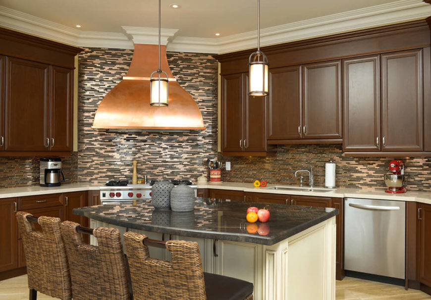 Browns, grays, and golds create this room which is centered around the showcase piece of the copper stove hood, which visually dominates the room. Metallic tiles in the walls carry the finish around the room and breaks up the flat chocolate brown of the cabinets. Wicker chair backs mimic the patterning in the backsplash. Browns, grays, and golds create this room which is centered around the showcase piece of the copper stove hood, which visually dominates the room. Metallic tiles in the walls carry the finish around the room and breaks up the flat chocolate brown of the cabinets. Wicker chair backs mimic the patterning in the backsplash.