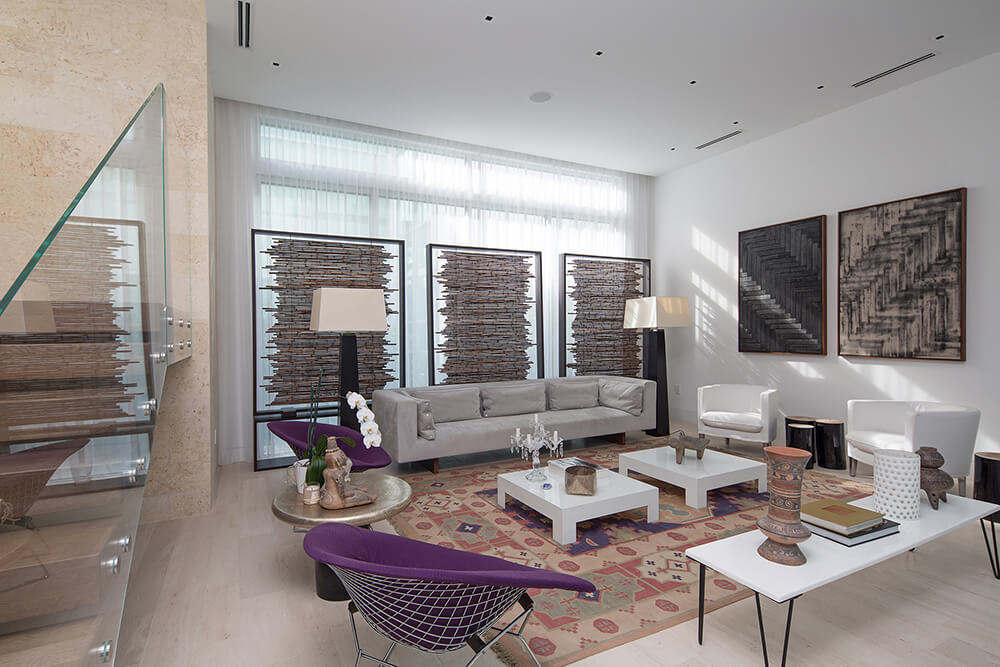 This formal living room boasts a set of modish seats along with nice wall decors and a rug.