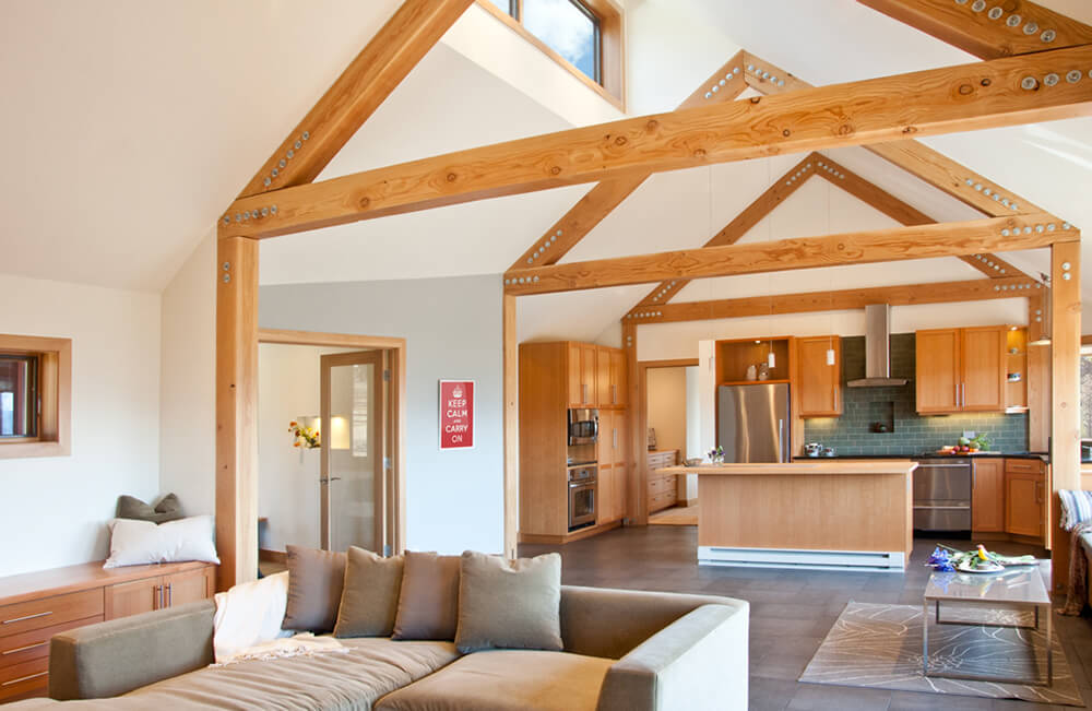 A great room under the vaulted ceiling with exposed beams and is surrounded by white walls.