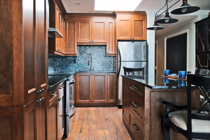 Unique backsplash. Kitchen with walnut cabinetry and hardwood flooring along with unique backsplash and breakfast bar.