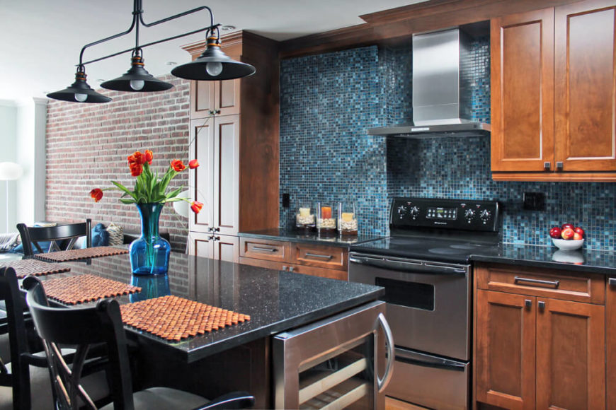 Close up of unique backsplash. Kitchen with walnut cabinetry and granite countertops along with unique backsplash.
