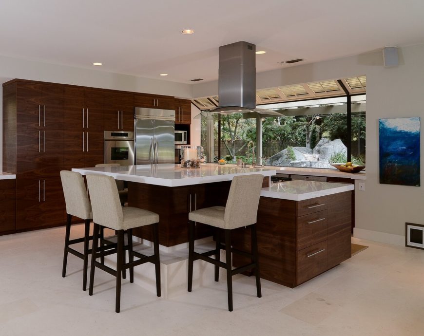Quartz Countetops Large kitchen with white walls and wooden cabinetry along with stainless steel appliances and quartz countetops featuring a breakfast bar.