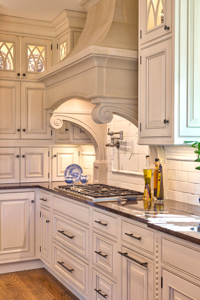 Kitchen covered by white walls and white cabinetry featuring white brick backsplash and solid countertops.