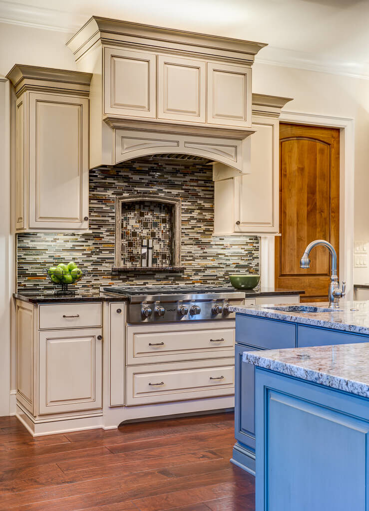 Kitchen with hardwood flooring and stylish camou backsplash along with a center island featuring a marble countertop.