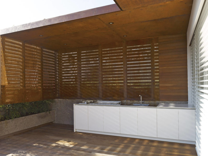 Close up view of the outdoor kitchen on deck featuring a white counter lighted by recessed ceiling lights.