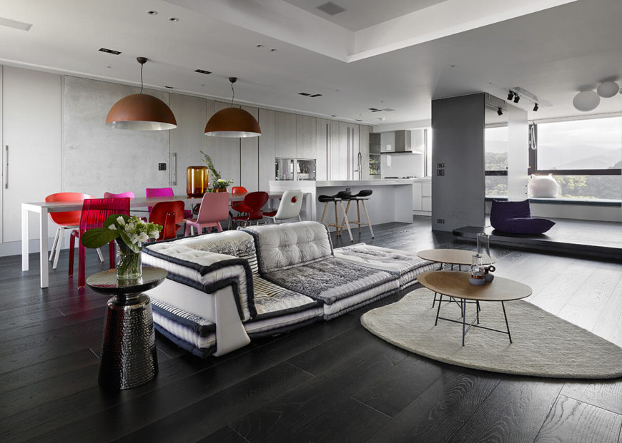 White kitchen with espresso hardwood flooring. The kitchen also features a large center island with a breakfast bar and a dine-in table set.