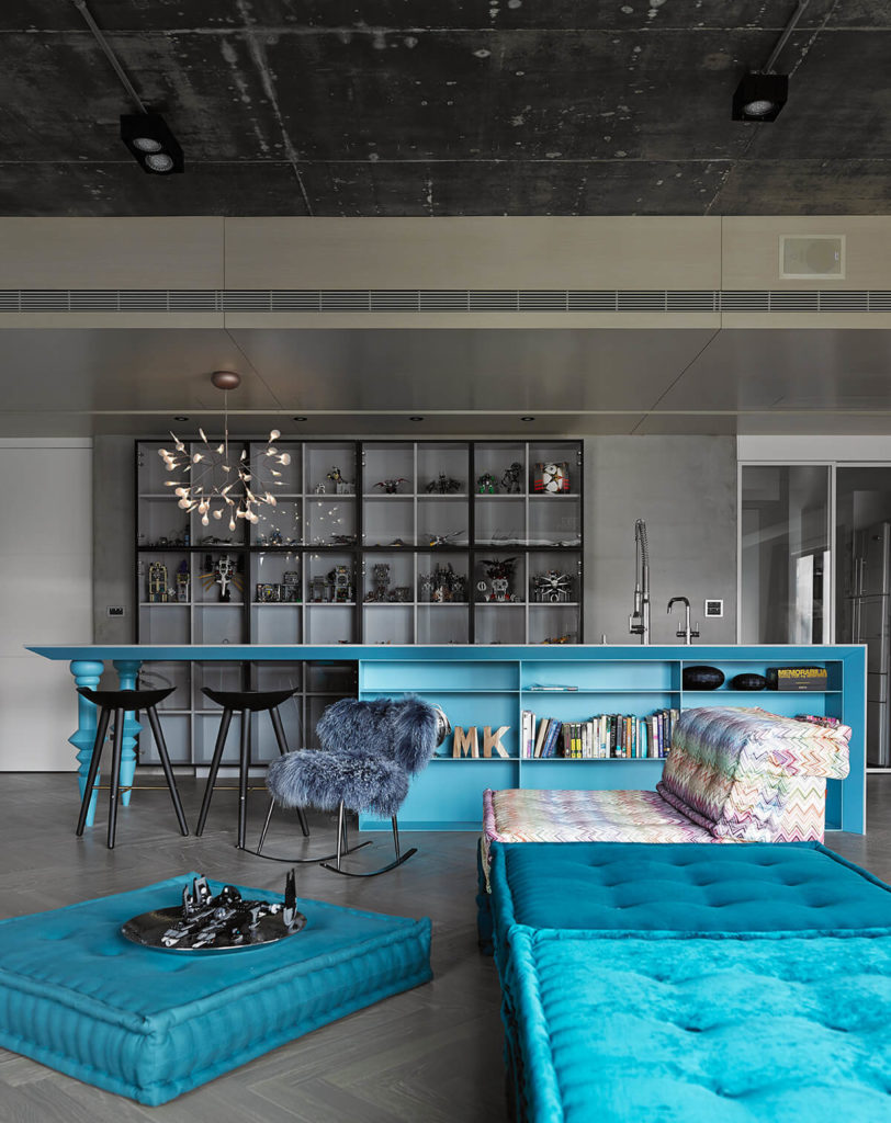 Kitchen with blue center island and a breakfast bar along with multiple shelving at the back.