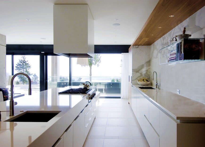 Single wall kitchen with marble backsplash and smooth countertops along with a large center island and tiles flooring.
