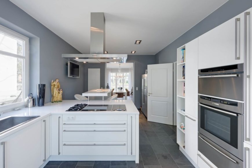 Kitchen with smart appliances and white cabinetry along with smooth white countertops and tiles flooring.
