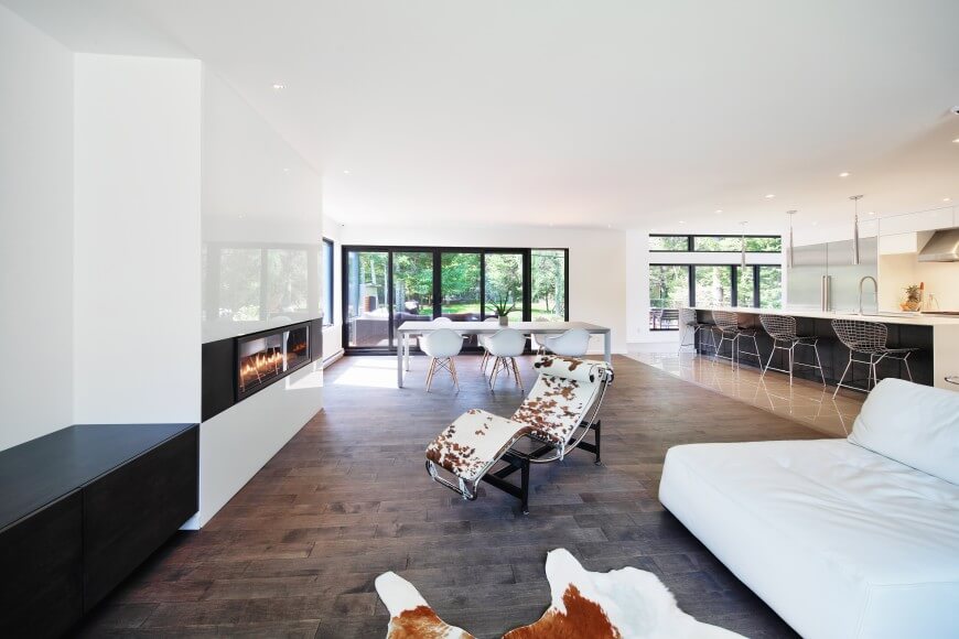 Huge kitchen with white walls and countertops along with a large center island and a dine-in table set.