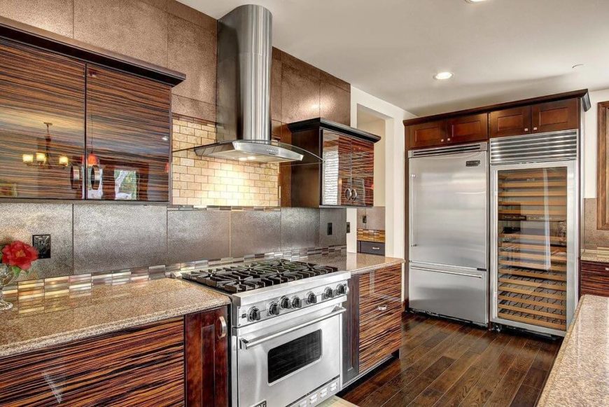 We love the sleek texture of the wood cabinetry in this kitchen, adding a glossy sheen to a space dominated by the contrast between natural wood and stainless steel. The countertops and backsplash provide an abundance of textural detail as well. We love the sleek texture of the wood cabinetry in this kitchen, adding a glossy sheen to a space dominated by the contrast between natural wood and stainless steel. The countertops and backsplash provide an abundance of textural detail as well.