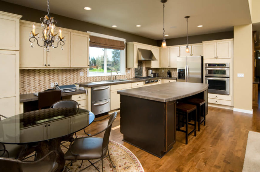 The highly textural tile backsplash of this kitchen adds an attention grabbing layer to this contemporary kitchen, sandwiched between layers of light hued cabinetry over a hardwood floor. The massive island features a light brown countertop and dark stained wood body, in sharp contrast to the bright stainless steel appliances. The highly textural tile backsplash of this kitchen adds an attention grabbing layer to this contemporary kitchen, sandwiched between layers of light hued cabinetry over a hardwood floor. The massive island features a light brown countertop and dark stained wood body, in sharp contrast to the bright stainless steel appliances.