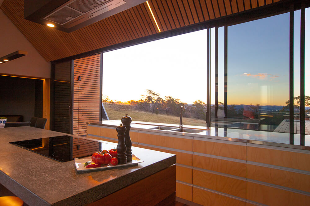 A focused shot at this galley kitchen's glass window overlooking the beautiful surroundings around the property.