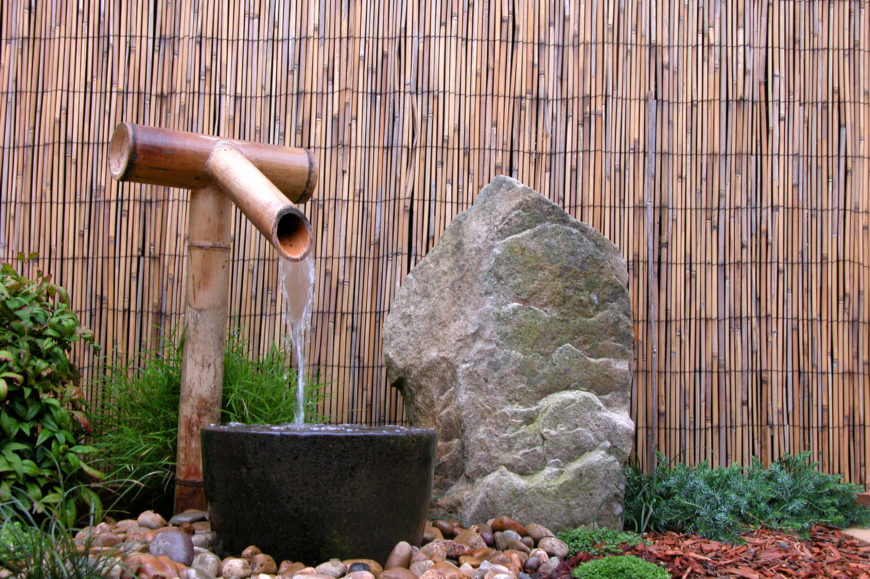 Bamboo is at its most beautiful when placed as a decorative fence around a traditional Japanese Zen garden. This particular fence acts as a backdrop to a water feature and mossy stone. Bamboo is at its most beautiful when placed as a decorative fence around a traditional Japanese Zen garden. This particular fence acts as a backdrop to a water feature and mossy stone.