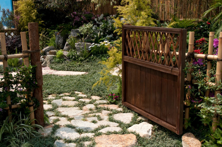 This decorative "picket" bamboo is attached to a dark stained solid wood gate and terminal posts, providing access to the lush back garden via a slightly overgrown flagstone pathway. This decorative "picket" bamboo is attached to a dark stained solid wood gate and terminal posts, providing access to the lush back garden via a slightly overgrown flagstone pathway.