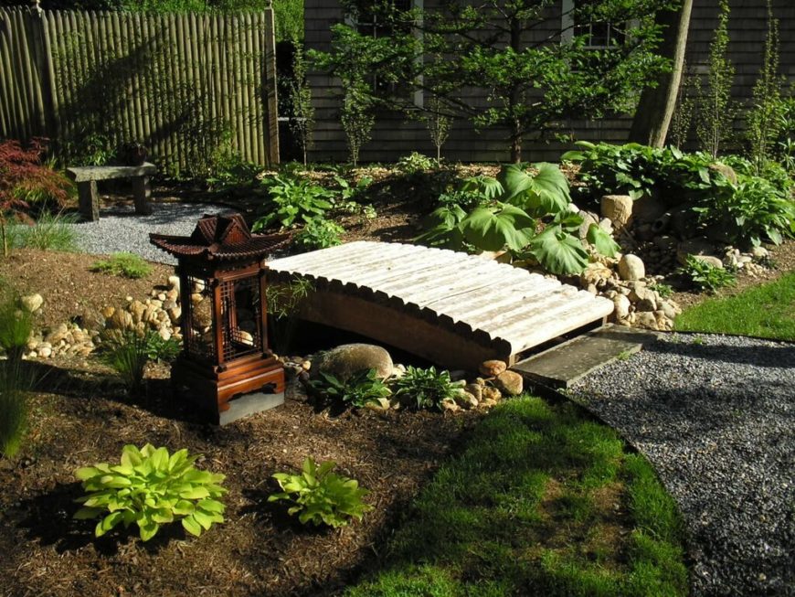 A beautiful Zen garden with a tall bamboo fence. Unlike most bamboo fences, which have cut-off tops, this fence has pointed tops, similar to more western style fences. A beautiful Zen garden with a tall bamboo fence. Unlike most bamboo fences, which have cut-off tops, this fence has pointed tops, similar to more western style fences.