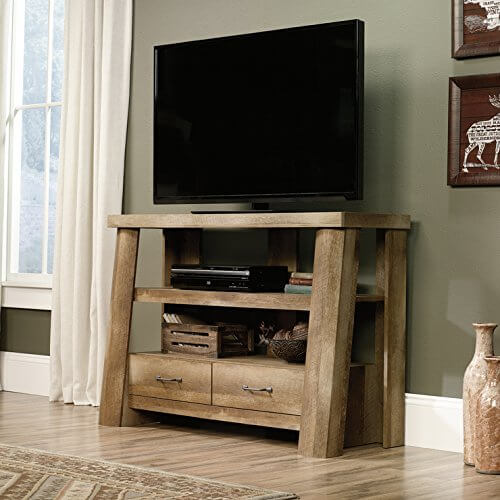 The unvarnished tone of the wood used in this gorgeously simple TV stand gives it an almost rustic look, but the sturdy framing, thick wood, and sharply creased drawers nail the Craftsman look. A stand like this would work perfectly in a similarly trimmed room, or stand out as an accent in a more modern styled space. The unvarnished tone of the wood used in this gorgeously simple TV stand gives it an almost rustic look, but the sturdy framing, thick wood, and sharply creased drawers nail the Craftsman look. A stand like this would work perfectly in a similarly trimmed room, or stand out as an accent in a more modern styled space.