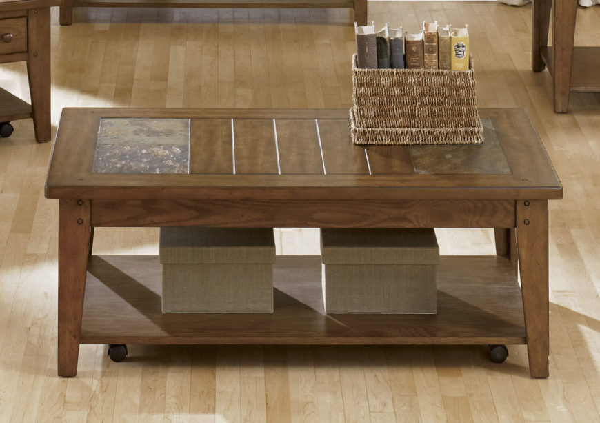 This rich natural wood coffee table is an exemplary form of Craftsman style, with thick clearly defined slats and solid legs forming a simple but elegant shape. The tabletop features a pair of natural slate accents for a bit of relatively extravagant style, plus a lower shelf for additional storage or display space. This rich natural wood coffee table is an exemplary form of Craftsman style, with thick clearly defined slats and solid legs forming a simple but elegant shape. The tabletop features a pair of natural slate accents for a bit of relatively extravagant style, plus a lower shelf for additional storage or display space.