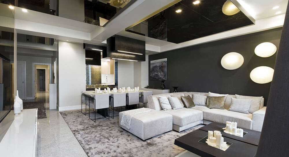 A great room with a luxurious setup. The tray ceiling is just so stunning along with the black walls.