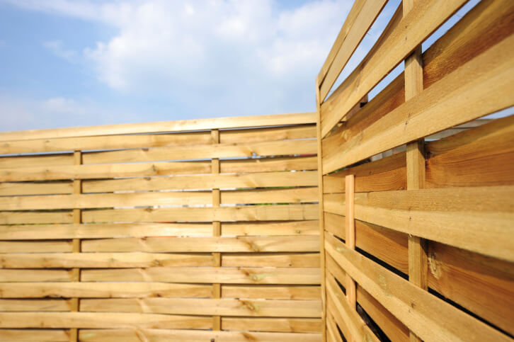 This privacy fence is in a much lighter stain, but the slats are staggered to allow the breeze through. This is a great design for areas that see severe weather. This privacy fence is in a much lighter stain, but the slats are staggered to allow the breeze through. This is a great design for areas that see severe weather.