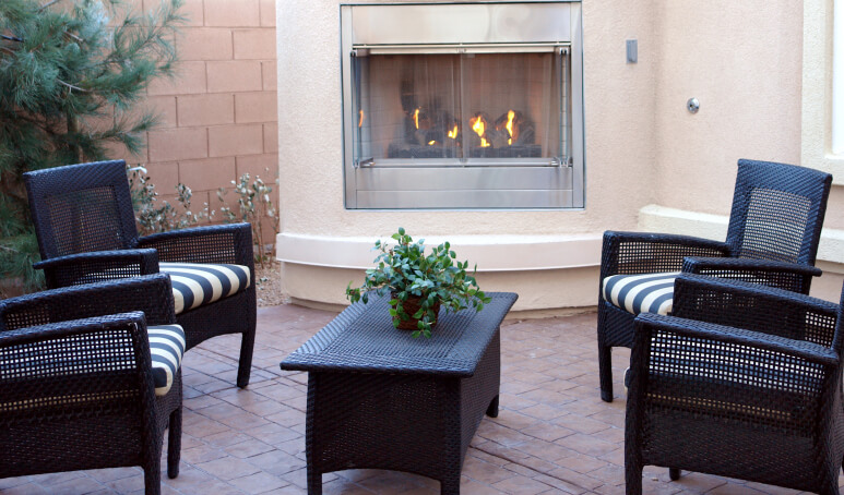This elegant patio fireplace is attached to the main home, creating a small bump out. The fireplace is screened in, preventing any crackling or popping embers from escaping. This elegant patio fireplace is attached to the main home, creating a small bump out. The fireplace is screened in, preventing any crackling or popping embers from escaping.