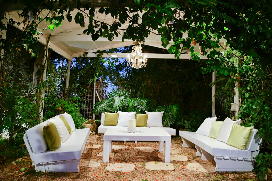 Another secluded patio underneath a large white pavilion. A small chandelier hangs from the center above the coffee table. Another secluded patio underneath a large white pavilion. A small chandelier hangs from the center above the coffee table.