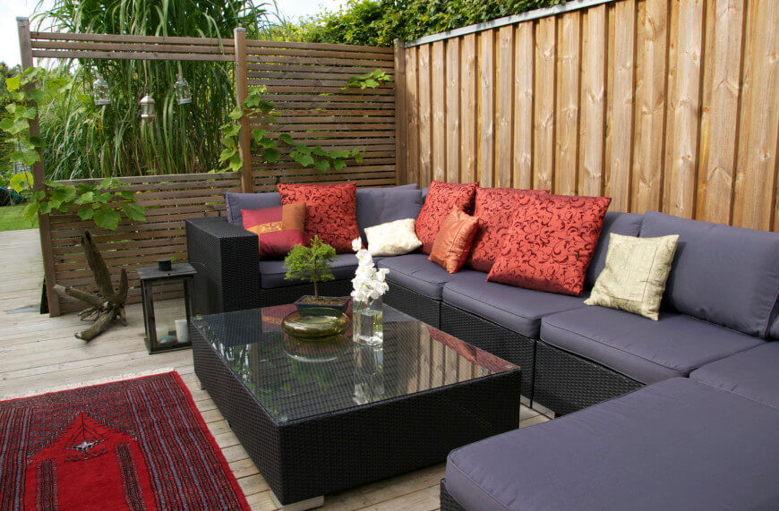 A private seating area is enhanced by adding a wooden screen to one side. Trailing vines draw the seating area back into the garden. A private seating area is enhanced by adding a wooden screen to one side. Trailing vines draw the seating area back into the garden.
