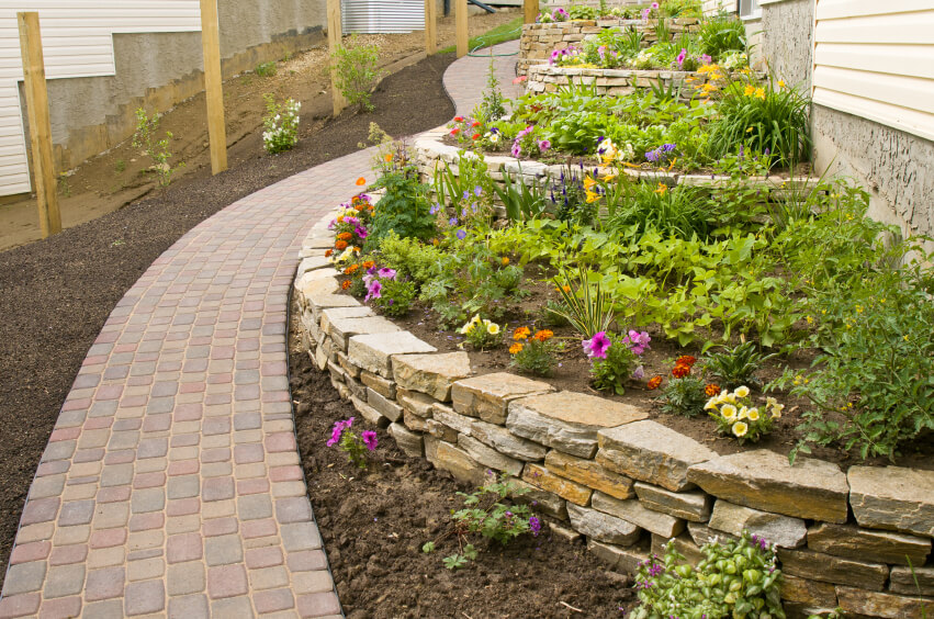 The stone terraces lead along the side of the house following the shape of the walkway running alongside it. The stone terraces lead along the side of the house following the shape of the walkway running alongside it.