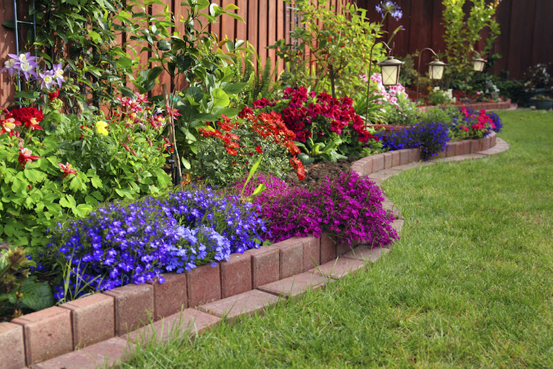 If you prefer a smooth edge, use pavers to easily define your flower beds. Then feel free to allow your plants mingle in an explosion of color. If you prefer a smooth edge, use pavers to easily define your flower beds. Then feel free to allow your plants mingle in an explosion of color.