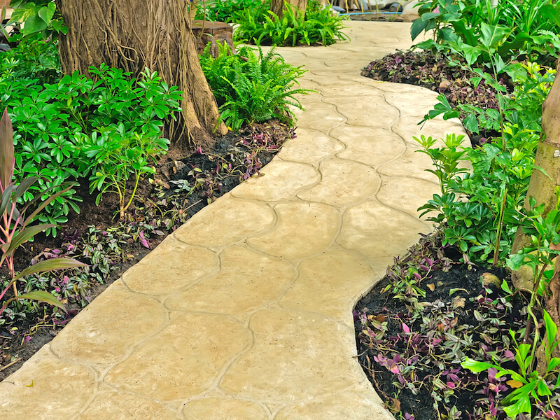 This lovely and subtle stone pathway winds its way through a more forested garden with large, mature trees. This lovely and subtle stone pathway winds its way through a more forested garden with large, mature trees.